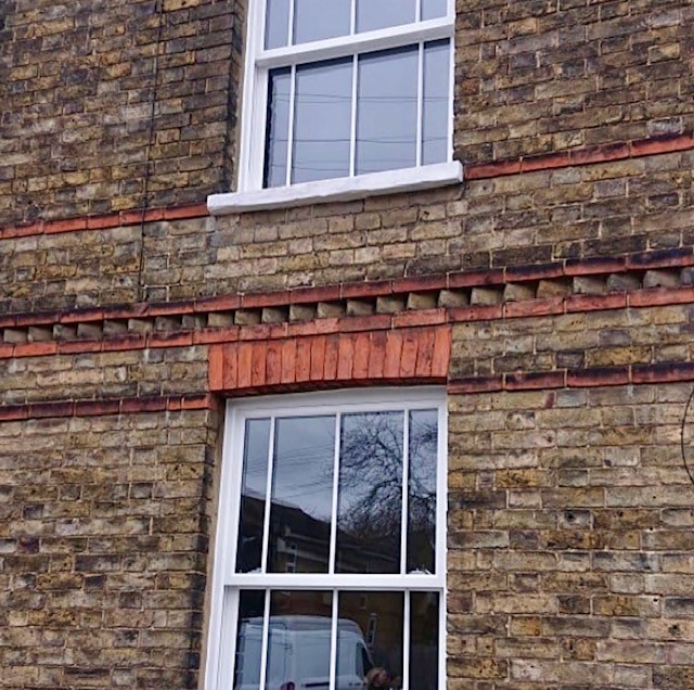 White upvc box sash windows installed in a victorian building